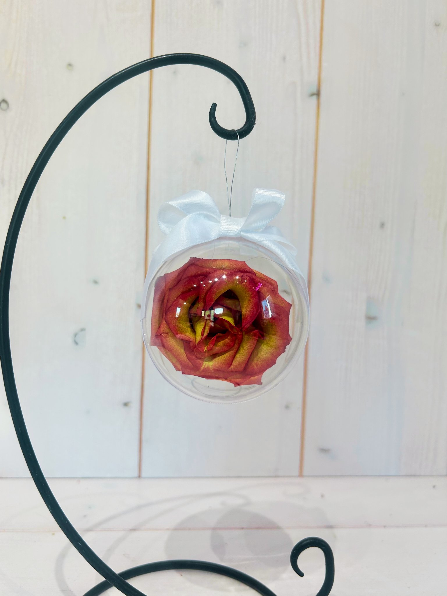 Preserved flower in acrylic ornament with metal stand